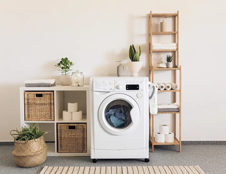 A tidy laundry room with a washing machine and baskets