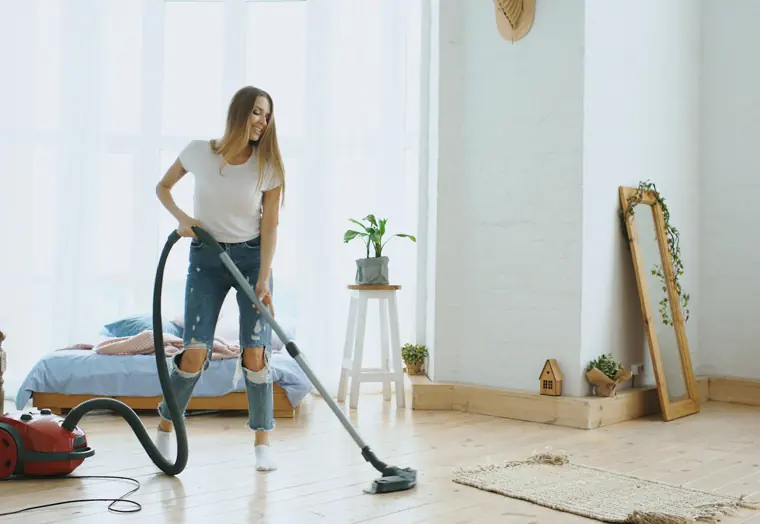 Residential cleaning: vacuuming a bright bedroom floor